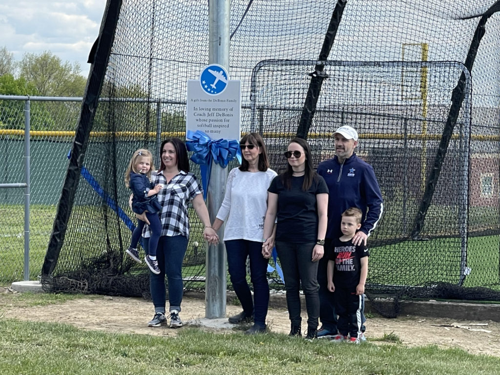 Debonis and Varney families in front of softball batting cage